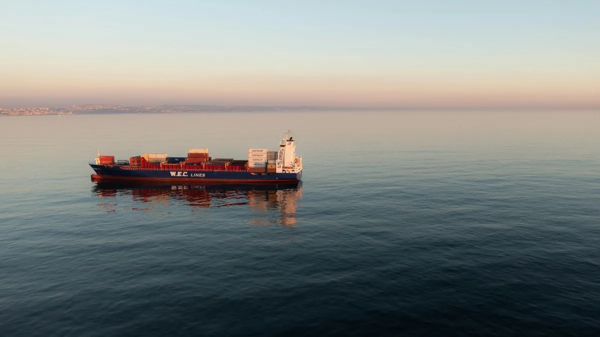 Container ship on calm open sea at dawn
