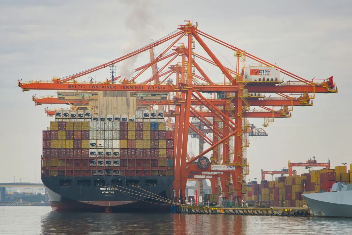 Grúas pórtico trabajando en un buque portacontenedores cargado en un muelle
