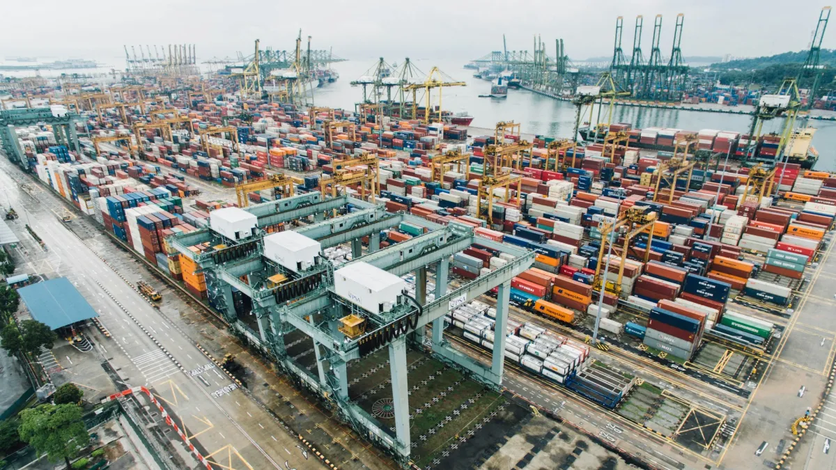 Panoramic view of an active commercial seaport with container ships, cranes, and port infrastructure.